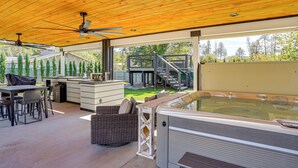 A covered outdoor area with a hot tub, seating, and a staircase leading to a deck. - Backyard Oasis w/ Hot Tub & Views: Weaverville Gem (Weaverville)