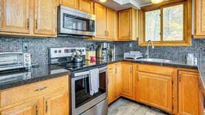 A kitchen with wooden cabinets, a stainless steel microwave, a toaster, and a kettle. - Luxury Home w/ Game Room, 4 Mi to Bushkill Falls! (Bushkill)