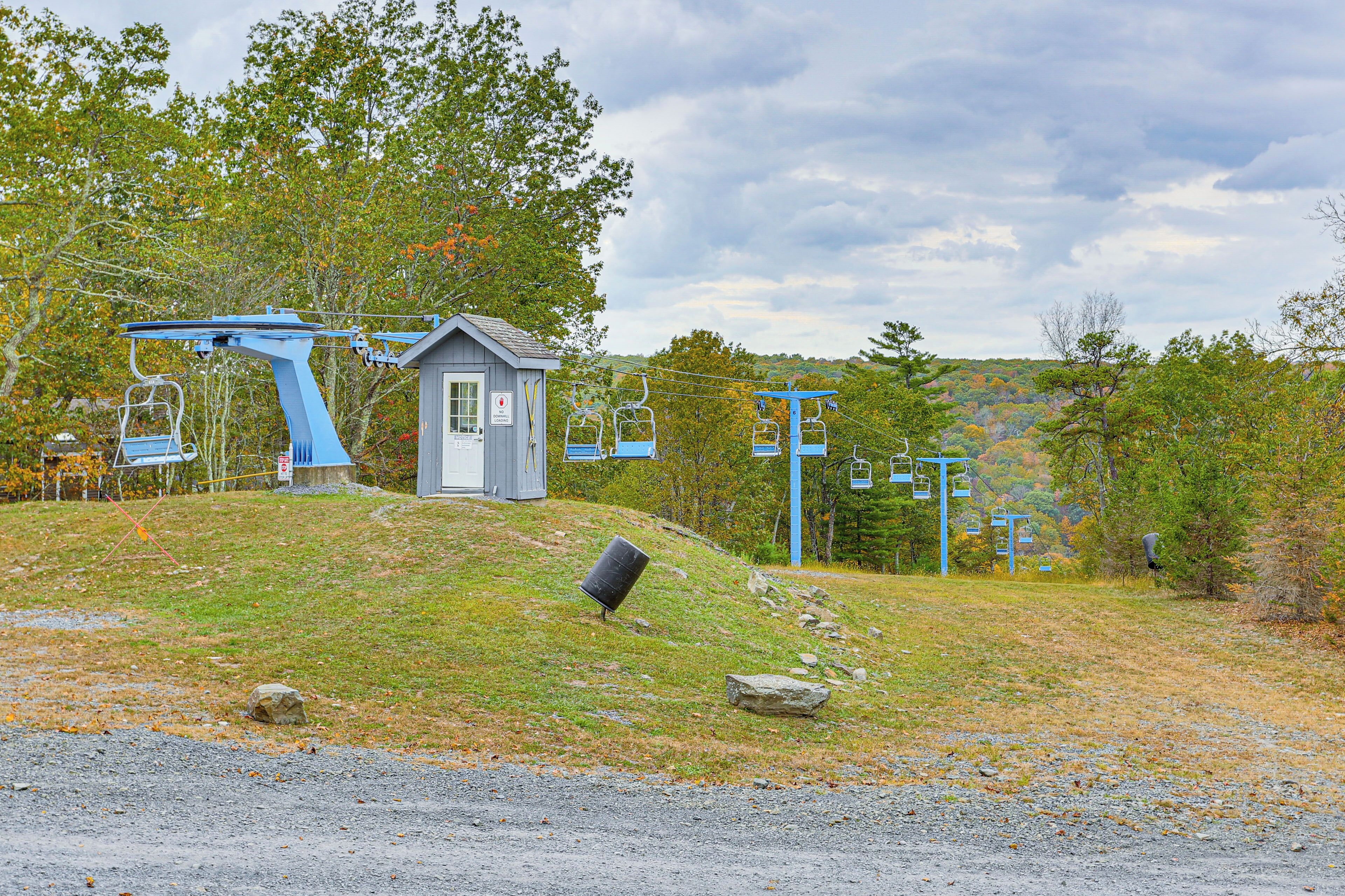 Une station de télésiège comprenant une petite cabane, un télésiège et une colline rocheuse.