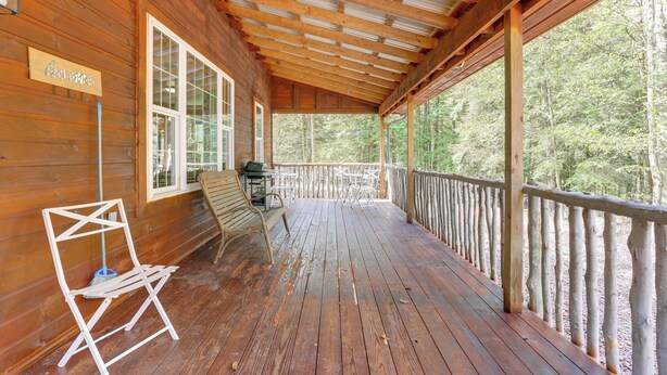A wooden deck with a covered area, a sign reading "Haven," and a view of the forest.