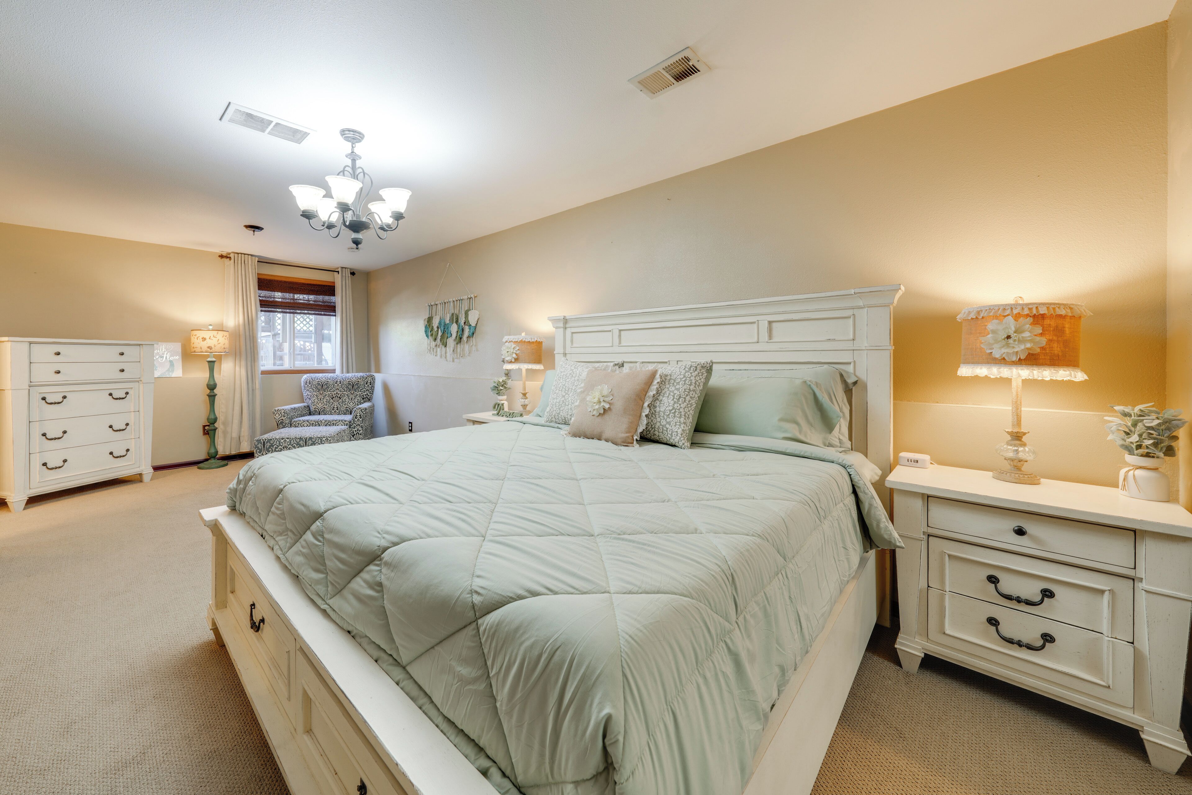 Une chambre à coucher avec un grand lit, une table de chevet, une commode et une chaise.