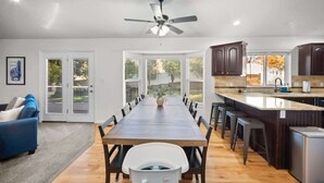 Una cocina moderna con una isla grande, armarios de madera oscura y un ventilador de techo.