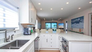 Una cocina moderna con armarios blancos, horno empotrado y una isla grande.