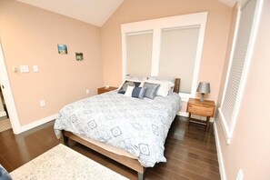 A bedroom with a large bed, a nightstand, a lamp, a window with blinds, and a small picture on the wall. - Updated home blocks from ND w/3 full baths (1015) (South Bend)