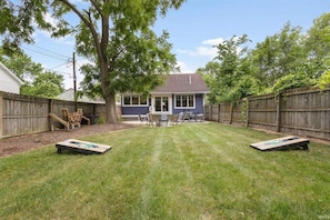 A backyard with a wooden deck, a lawn, and a house in the background. - Updated home blocks from ND w/3 full baths (1015) (South Bend)