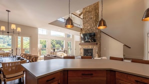 Una cocina amplia con una isla grande, armarios de madera y una pared decorativa de piedra.