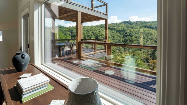 Una terraza de madera con vistas a un paisaje boscoso.