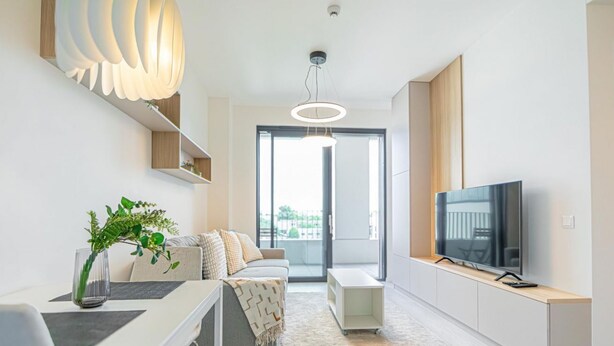 A modern living room with a sofa, TV, and a dining area with a table and chairs. - Stylish 1BR & 1LR Apartment | Cozy City View (Bratislava)
