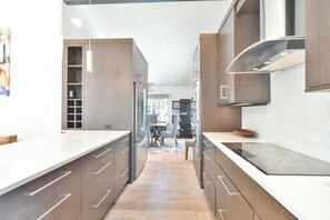 A modern kitchen with stainless steel appliances, wooden cabinets, and a white countertop. - You Are My Sunshine - Downtown Frisco Home (Frisco)