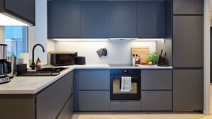 A modern kitchen with dark cabinetry, a built-in oven, and a stainless steel range hood. - Brand New & High-End, 3 Bedrooms 2 Bathrooms, Central Apartment (Bergen)