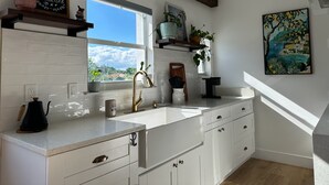 A modern kitchen with white cabinets, a large window, and a view of the outdoors. - Private duplex (second floor) centrally located to beaches and the city of Miami. (Miami)