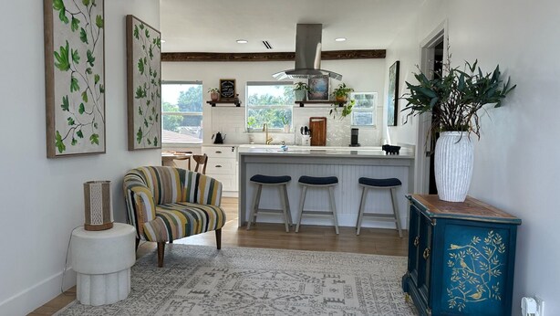A modern kitchen with a central island, bar stools, and a striped armchair. - Private duplex (second floor) centrally located to beaches and the city of Miami. (Miami)