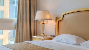 A hotel room with a bed, a nightstand, a lamp, and a window with curtains. - Luxury 1BR in Dubai Marina Beside Vida Yacht Club (Dubai)