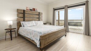 Une chambre avec un lit en bois, une table de chevet, une lampe et une vue sur un balcon.