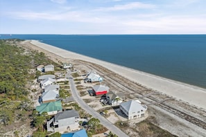 A coastal residential area with houses, a beach, and a clear view of the ocean. - Sea Of Love - 313 Audubon Pl 4 Bedroom Home (Dauphin Island)
