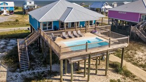 A beachfront house with a pool, deck, and multiple levels.