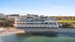 Een pand aan het water met meerdere niveaus, balkons en uitzicht op het strand.