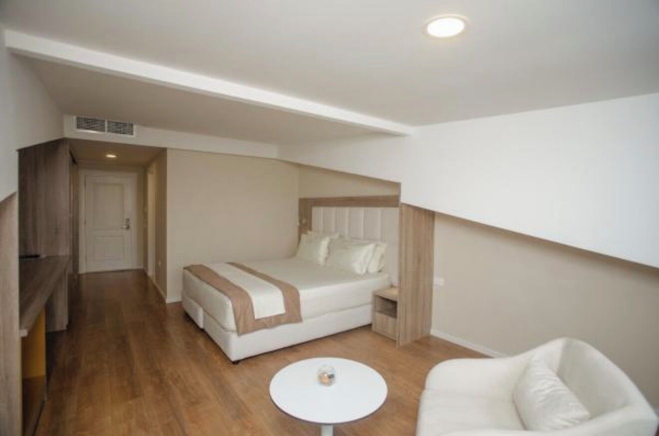 Une chambre à coucher avec un lit, une table de chevet et une petite table ronde.