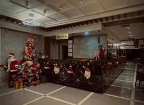 A reception area with a Christmas tree and a Santa Claus decoration. - Kompleksi Exalco-Al (Bushat)