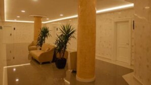 A spacious lobby with a polished floor, a reception desk, and two large columns. - Kompleksi Exalco-Al (Bushat)