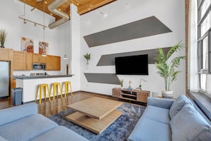 A modern living space with a kitchen, bar area, and seating. - Cozy mill loft w/ 2 king beds, gym & pool (Arcadia)