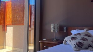 A hotel room with a bed, a nightstand, a lamp, and a painting on the wall. - B&B Lary (Pescara)