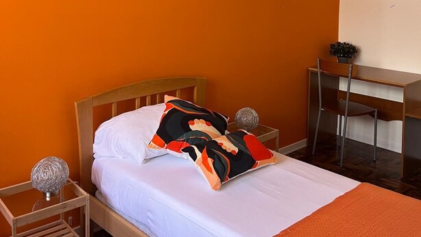 Une chambre à coucher avec un lit, un bureau et une chaise.
