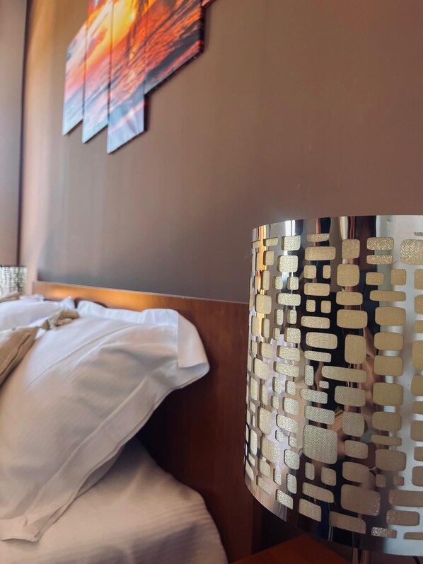 A hotel room with a bed, a headboard, and a decorative wall panel. - B&B Lary (Pescara)