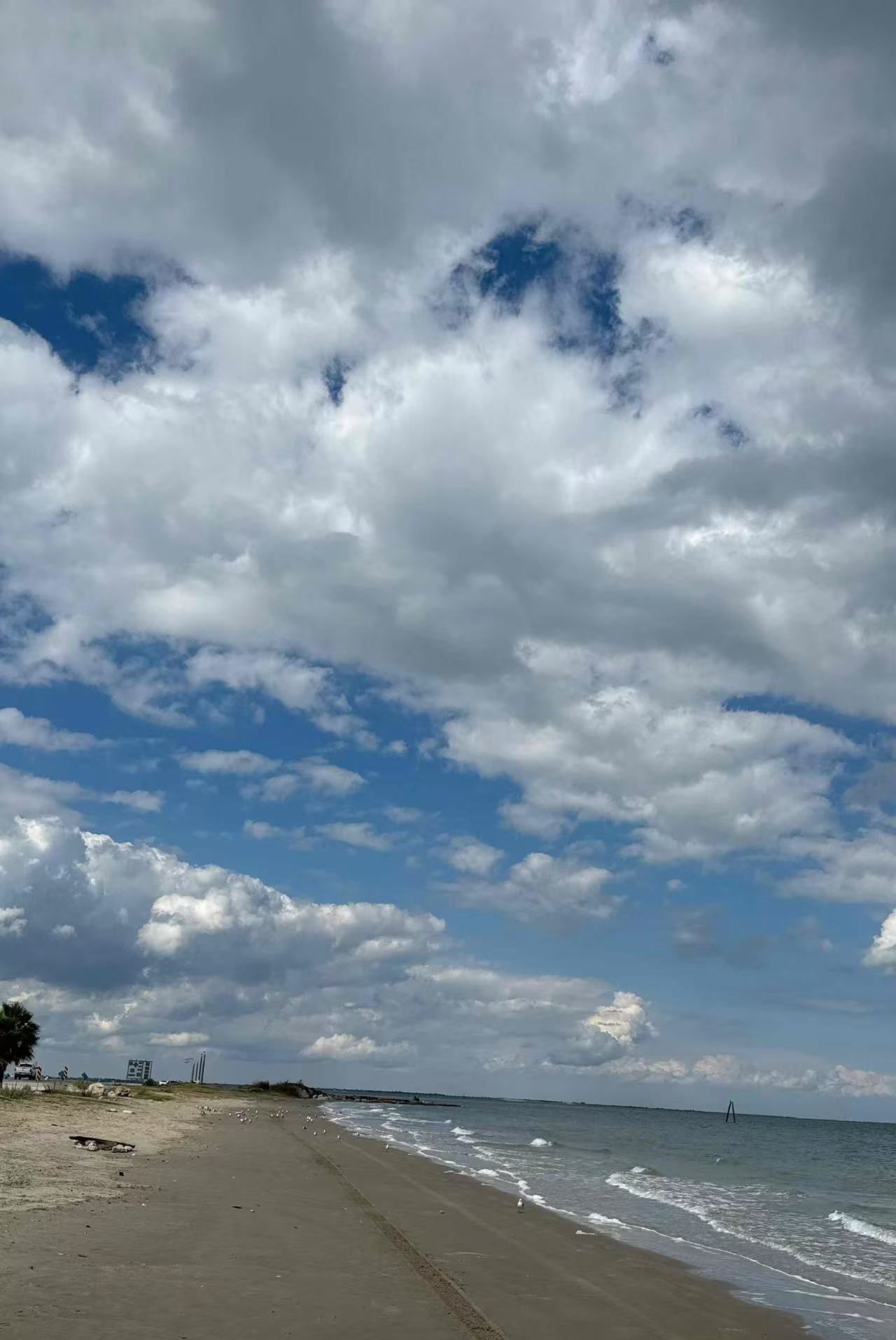A beach with a clear sky and clouds.