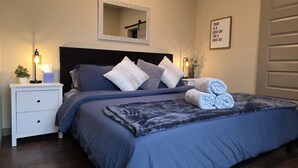 A bedroom with a bed, bedside tables, a mirror, and a motivational quote on the wall. - Near CDA Lake | Gym, In-Unit Laundry, Free Parking (Coeur d`Alene)