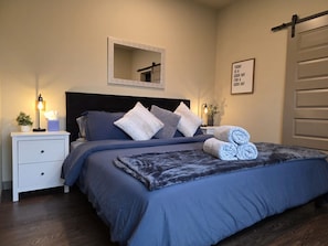 Una camera da letto con un letto, comodini, uno specchio e una citazione motivazionale sulla parete.