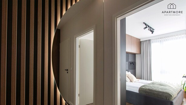 A modern bedroom with a bed, a mirror, and a ceiling light fixture. - City Center - Łąkowa street by Apartmore (Gdańsk)