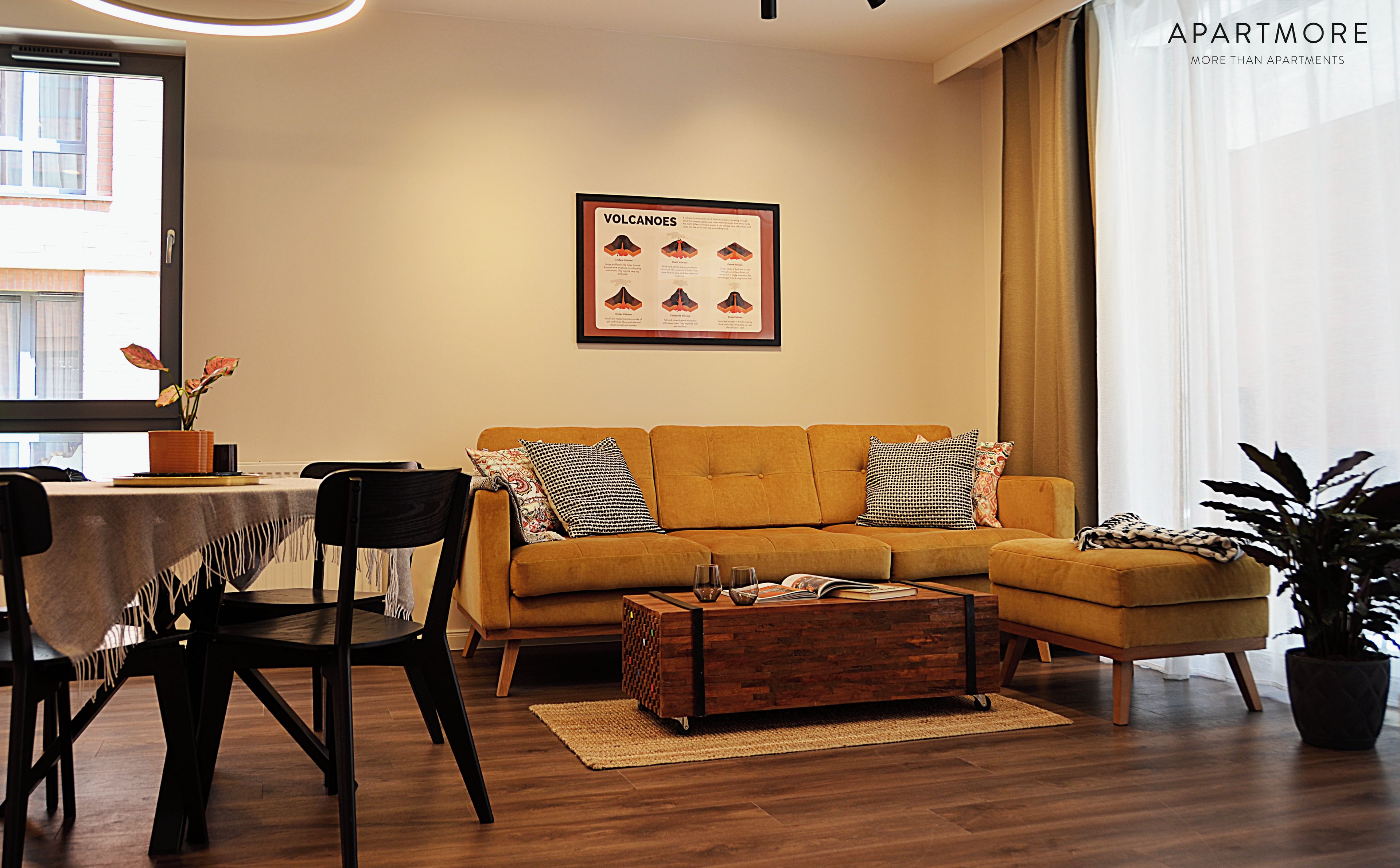 Un salon moderne avec un canapé, une table basse et une affiche encadrée accrochée au mur.
