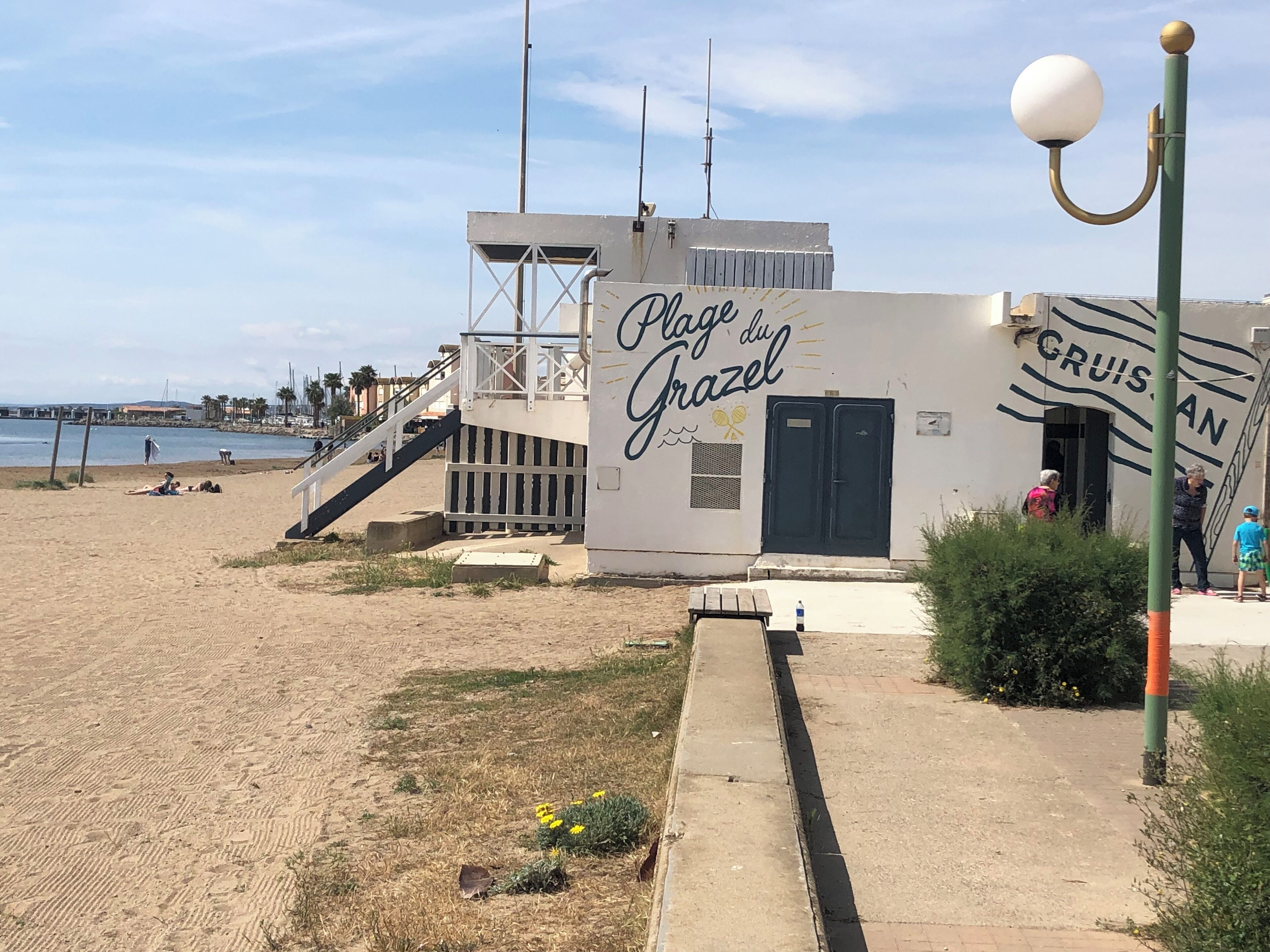 En bygning ved stranden med et skilt, der siger "Plays du Grazel".