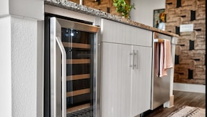 Eine Küche mit Einbaukühlschrank, Holzschränken und einem gemusterten Teppich.