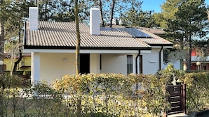 A two-story house with a tiled roof, a chimney, and a gated entrance. - Villa With Shared Pools and Garden (San Michele al Tagliamento)