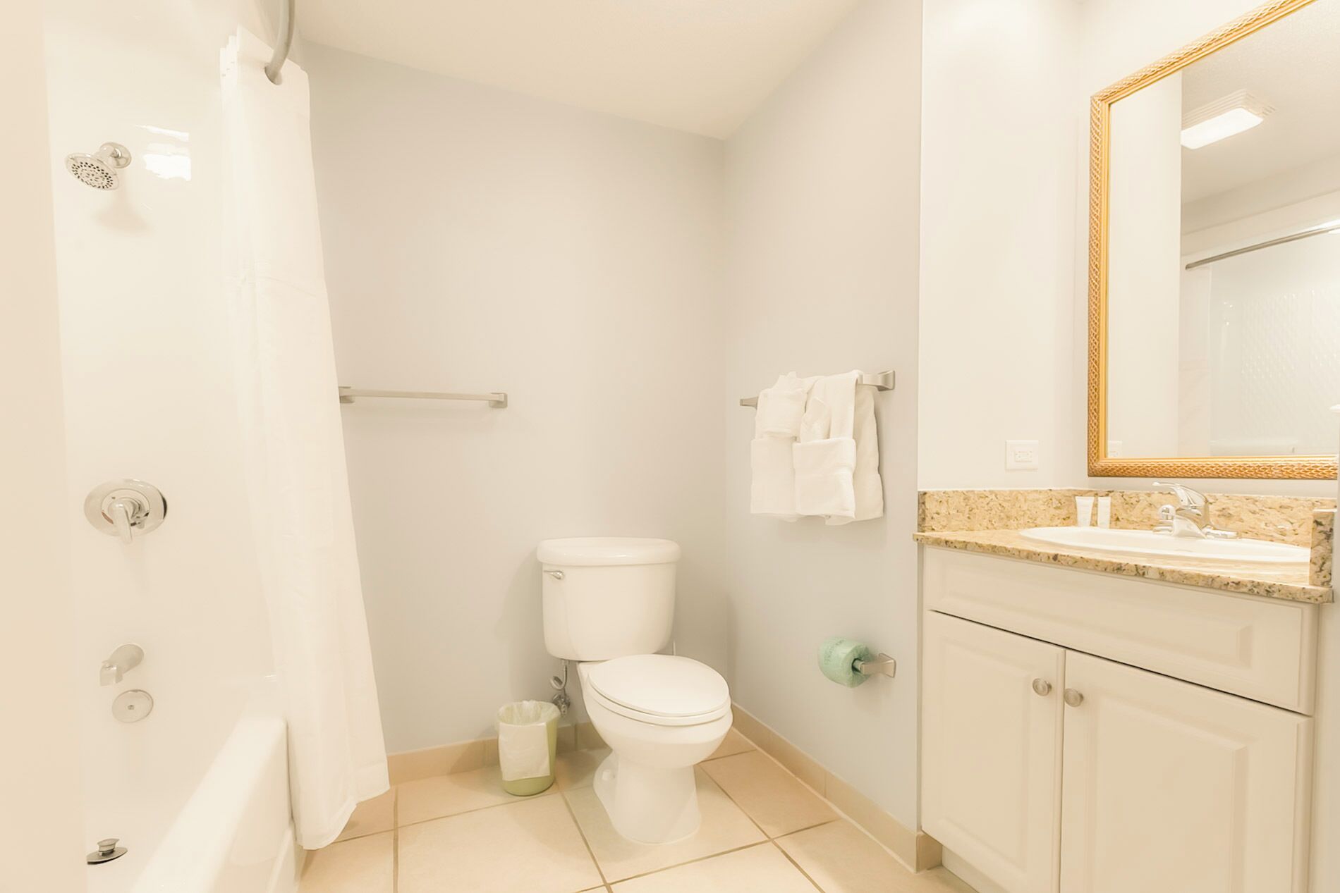 A bathroom with a toilet, sink, and mirror.