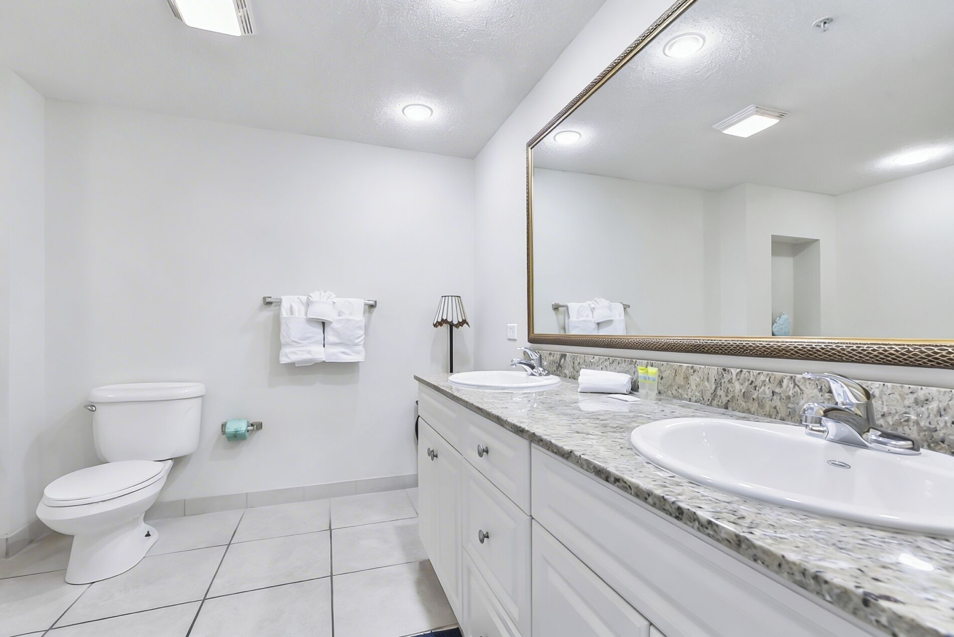 A modern bathroom with a toilet, sink, and mirror.