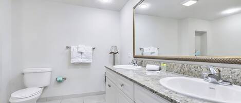 A modern bathroom with a toilet, sink, and mirror.