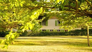 A building with a symmetrical facade, a central entrance, and a well-maintained lawn. - La Maison de Vacances 3 minutes from the ocean (La Flotte)