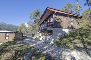 A wooden cabin with a balcony, surrounded by trees and a mountainous backdrop. - Relaxing holiday  in the nature (Borca di Cadore)