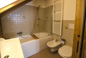 A bathroom with a bathtub, a bidet, and a toilet. - Relaxing holiday  in the nature (Borca di Cadore)