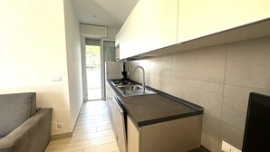A compact kitchen with a built-in stove, sink, and cabinets. - Apartment With Garden-beahost (San Michele al Tagliamento)