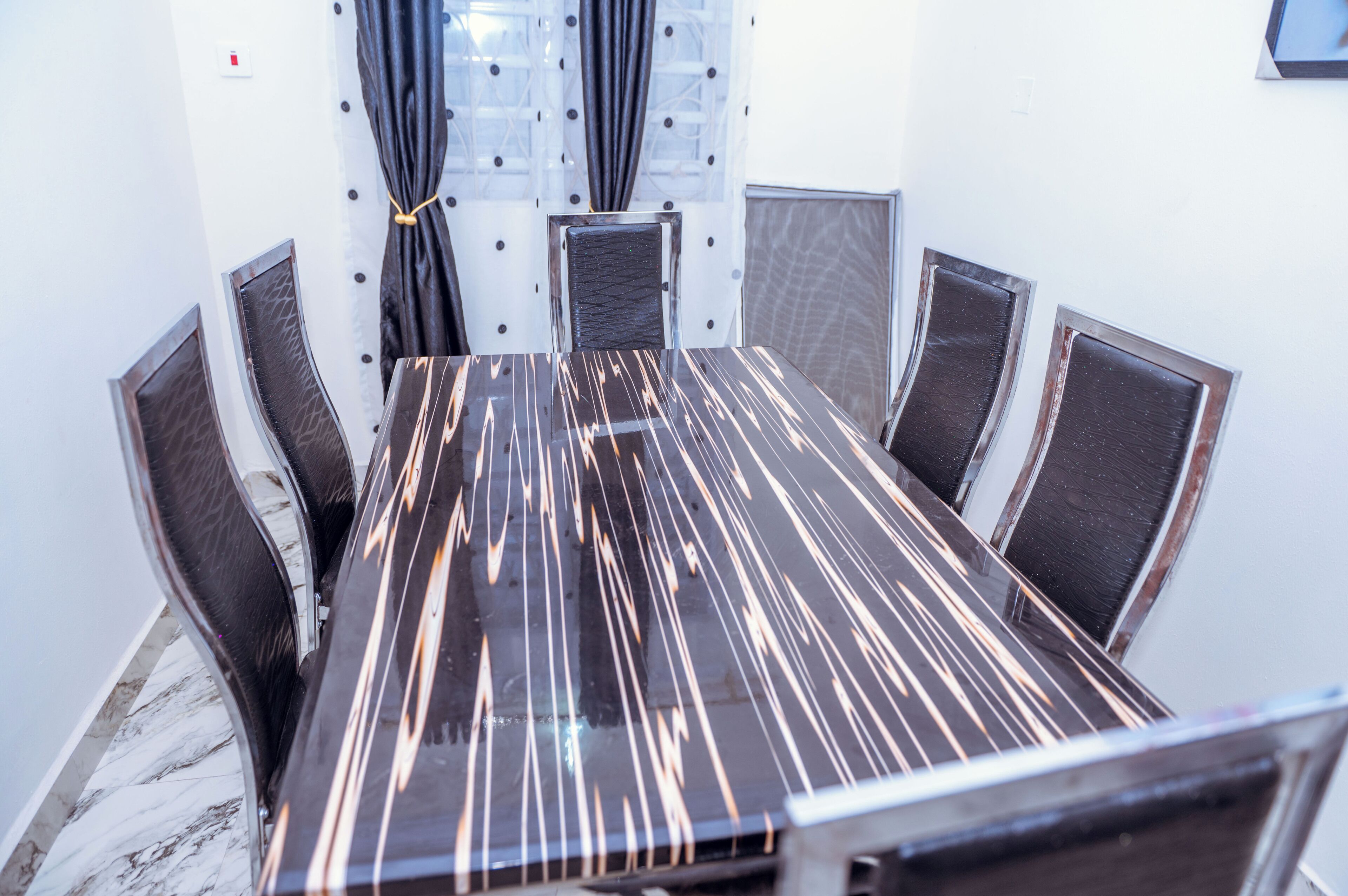 Une salle de conférence avec une table rectangulaire et six chaises.