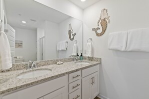 A bathroom with two sinks, a large mirror, and decorative wall art.