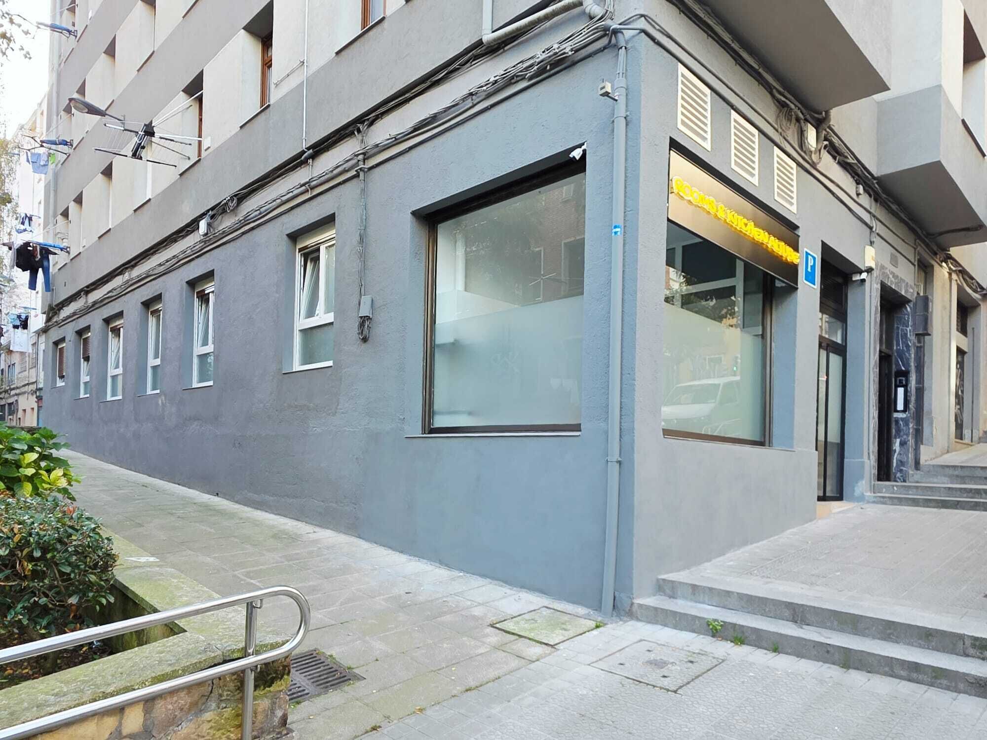 Un bâtiment doté d’une grande fenêtre, d’une porte et d’un panneau indiquant un parking avec la lettre « P ».