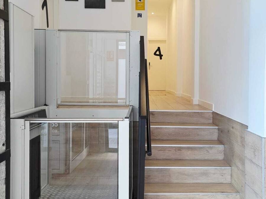 A staircase leading to a second floor with a glass door at the bottom.