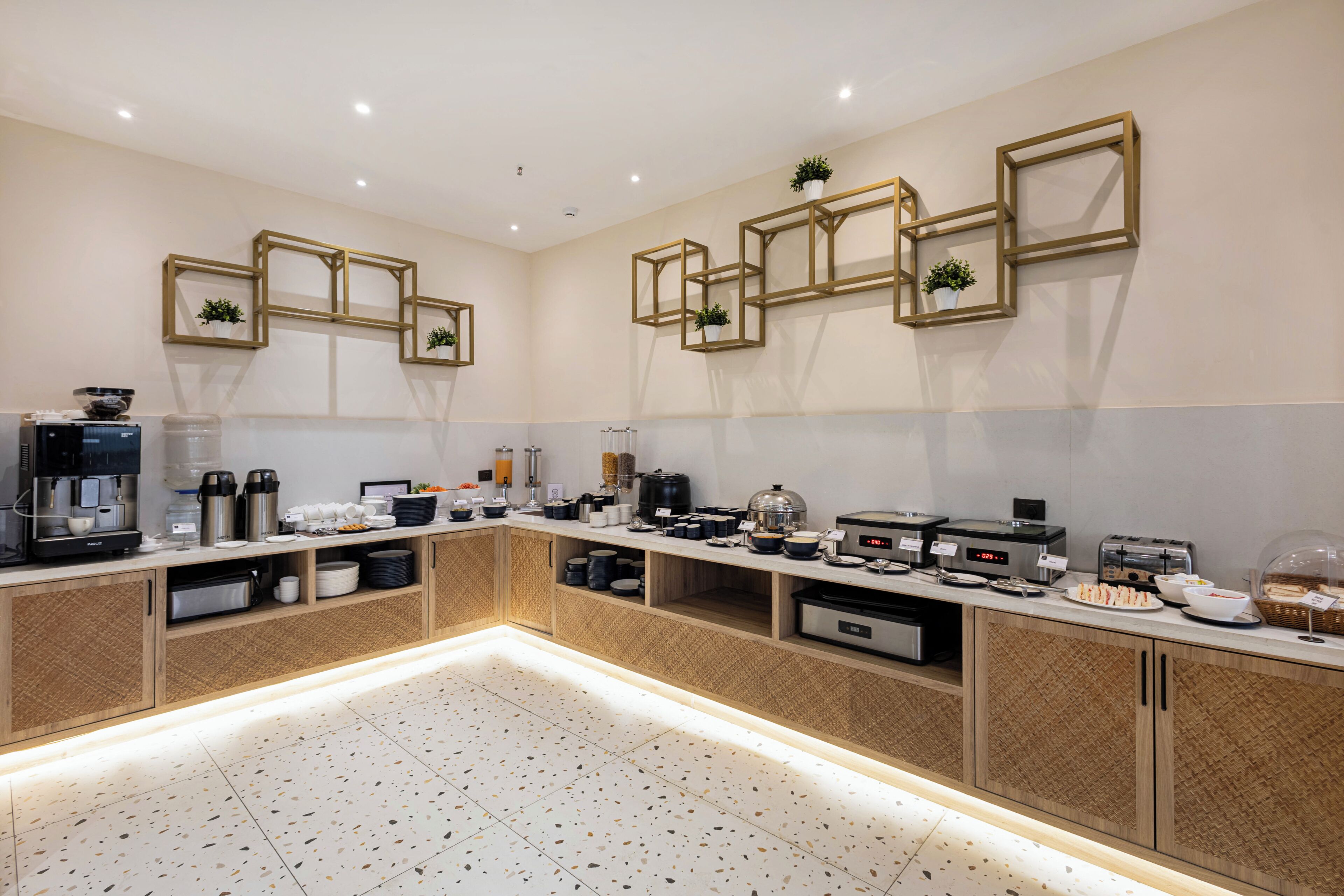 A modern kitchen with built-in appliances, a central island, and decorative wall mirrors.