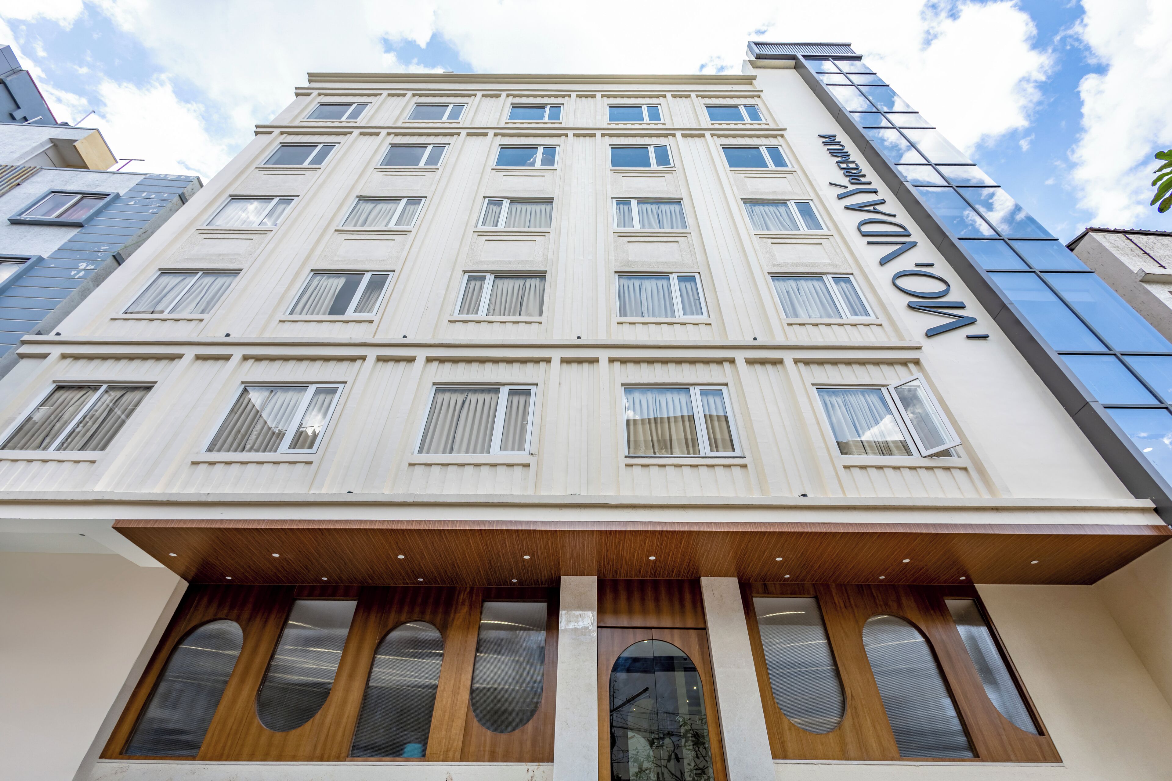 A multi-story hotel with a modern facade, large windows, and a prominent entrance with wooden accents.