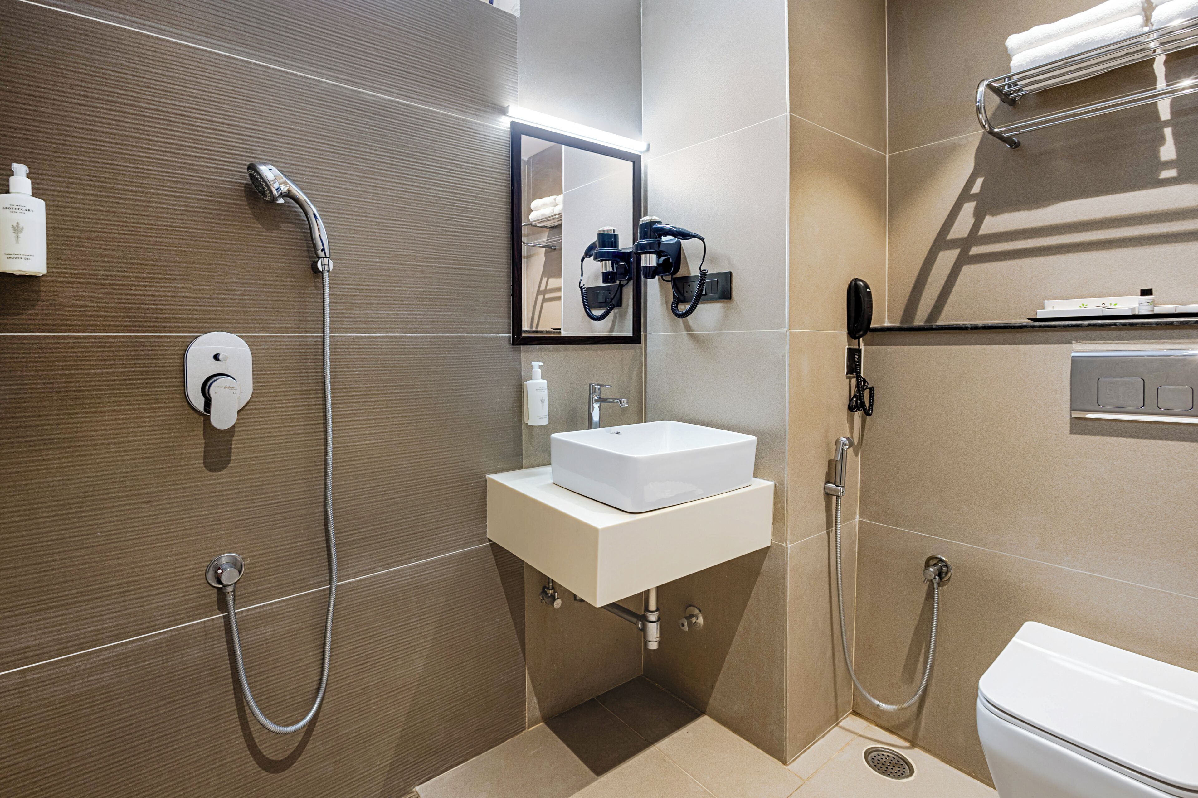 Un baño moderno con ducha, lavamanos e inodoro.